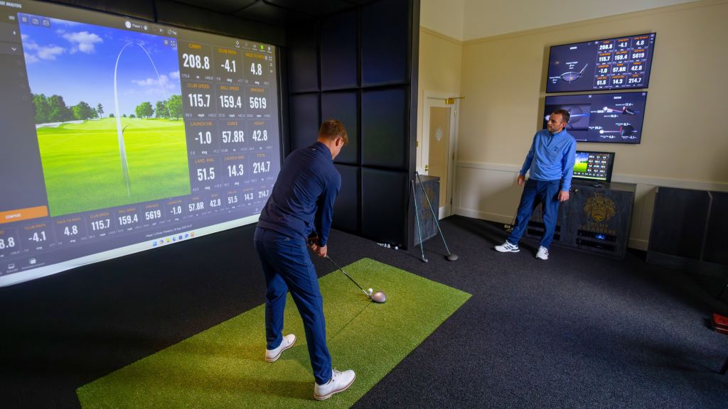 Guests using a TrackMan golf simulator