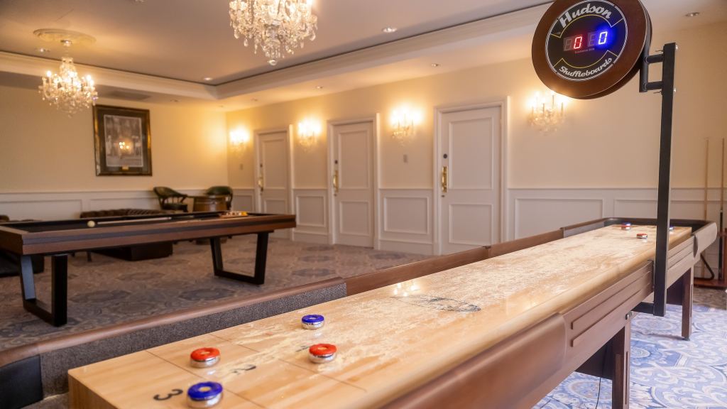 A lounge with a shuffleboard table and billiards