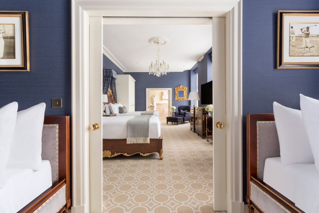 A hotel suite with the bedroom beyond the sitting room